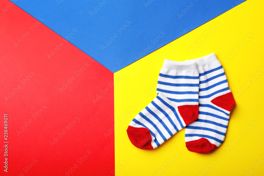Pair of cute child socks and space for text on color background, top view Pair of cute child socks and space for text on color background, top view