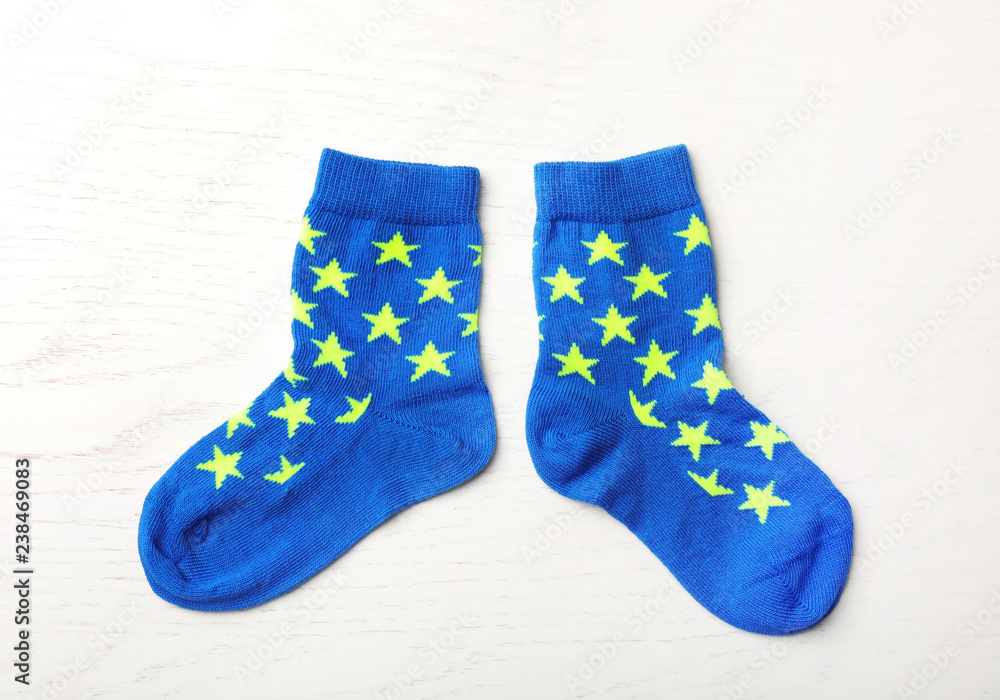 Pair of cute child socks on white wooden background, top view Pair of cute child socks on white wooden background, top view