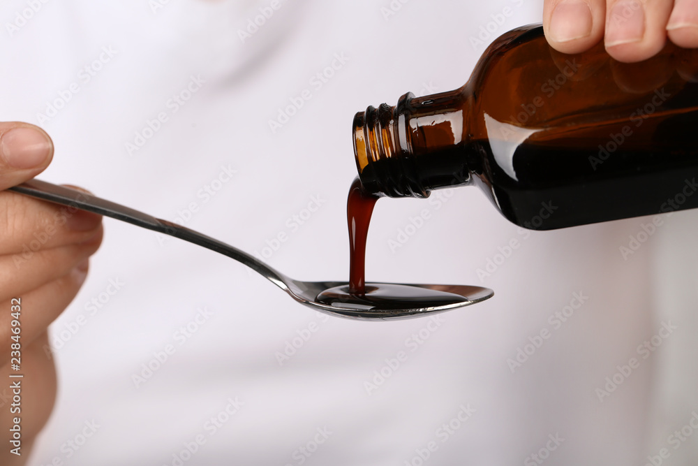 Woman pouring cough syrup into spoon, closeup Stock Photo Adobe Stock