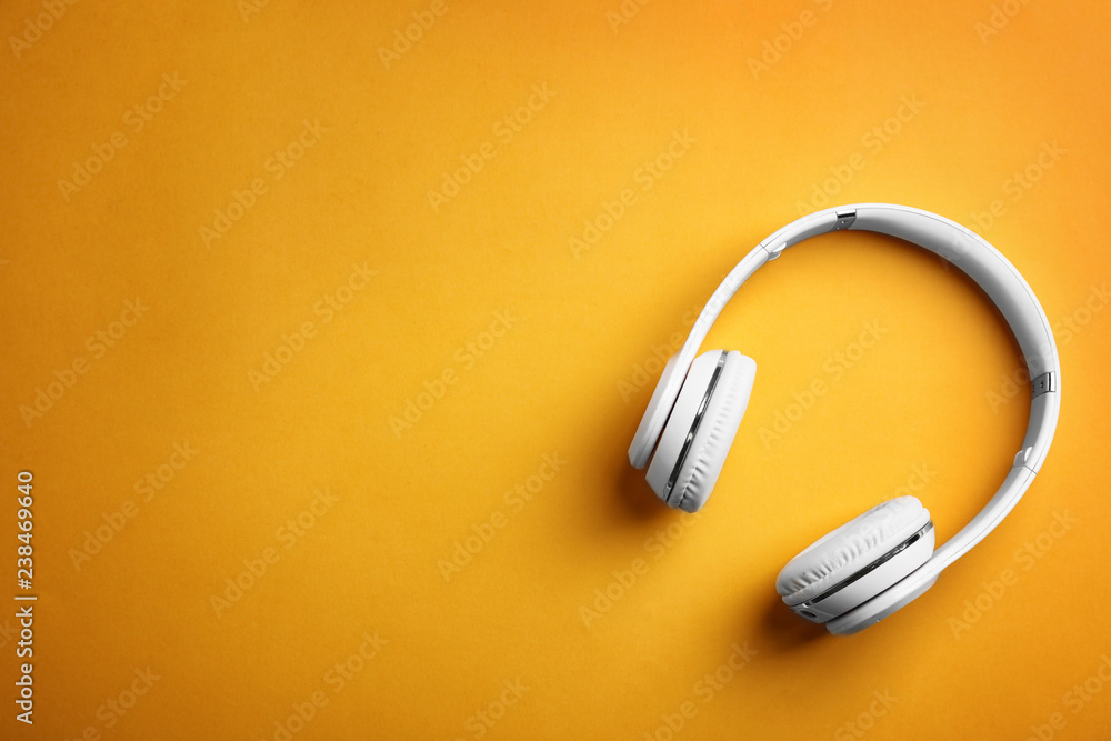 Wireless headphones on color background, top view. Space for text Wireless headphones on color background, top view. Space for text