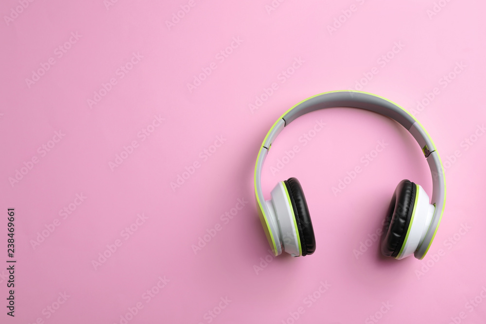 Wireless headphones on color background, top view. Space for text Wireless headphones on color background, top view. Space for text