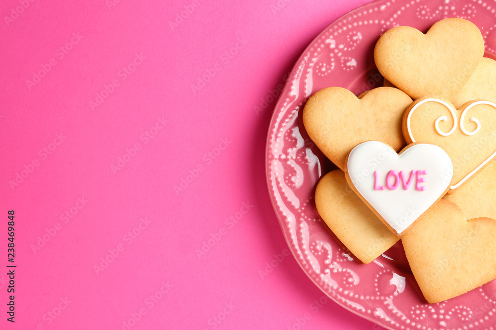Obraz premium Plate with decorated heart shaped cookies and space for text on color background, top view. Valentine's day treat