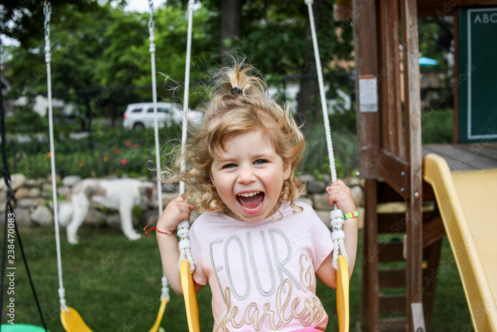 Portrait of girl screaming while swinging in playground