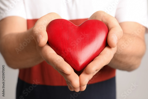 Man holding red decorative heart  closeup view