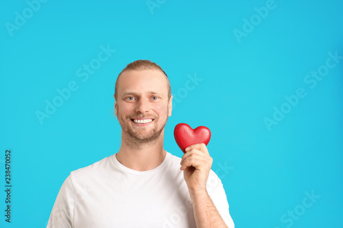 Portrait of man with decorative heart on color background. Space for text