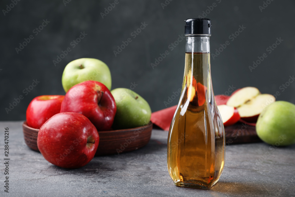 Composition with bottle of apple vinegar on table. Space for text Composition with bottle of apple vinegar on table. Space for text