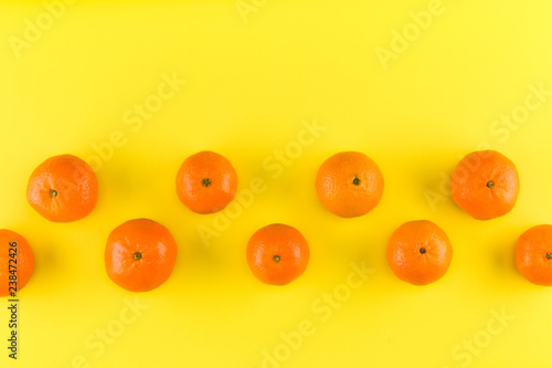 Fruit pattern of mandarin isolated on yellow background. Tangerine. Flat lay, top view. © Natika