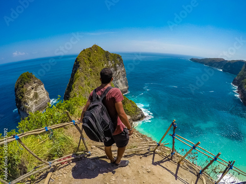 Man going all the way down to the Kelingking beach in Nusa Penida island of Indonesia