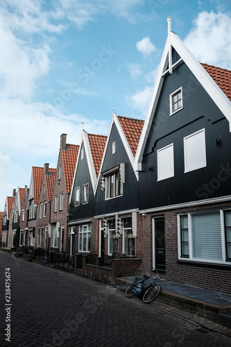 Houses in row by road against cloudy sky in city photo