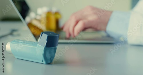 Doctor Using Laptop By Asthma Inhaler At Desk 4K