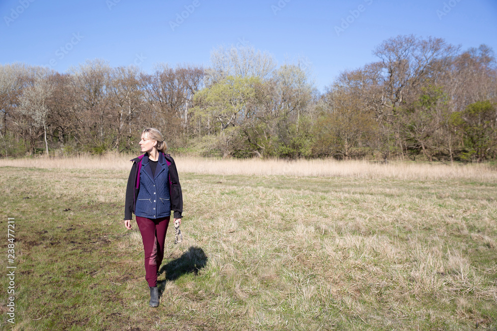 Full length of woman walking on grassy field during sunny day Full length of woman walking on grassy field during sunny day