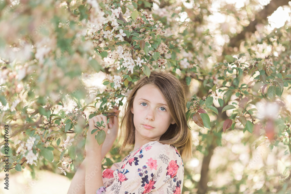Portrait of girl standing by tree in park