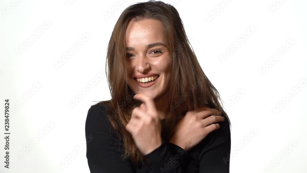 charming model is smiling and posing on a white background in the studio. Close-up charming model is smiling and posing on a white background in the studio. Close-up