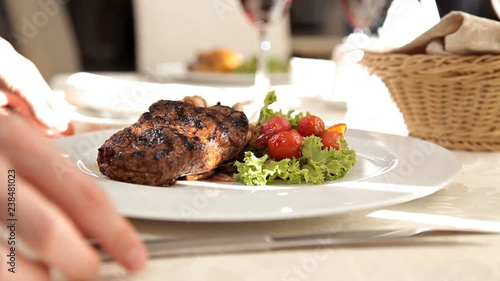 Waiter serving steak in a luxurious restaurant