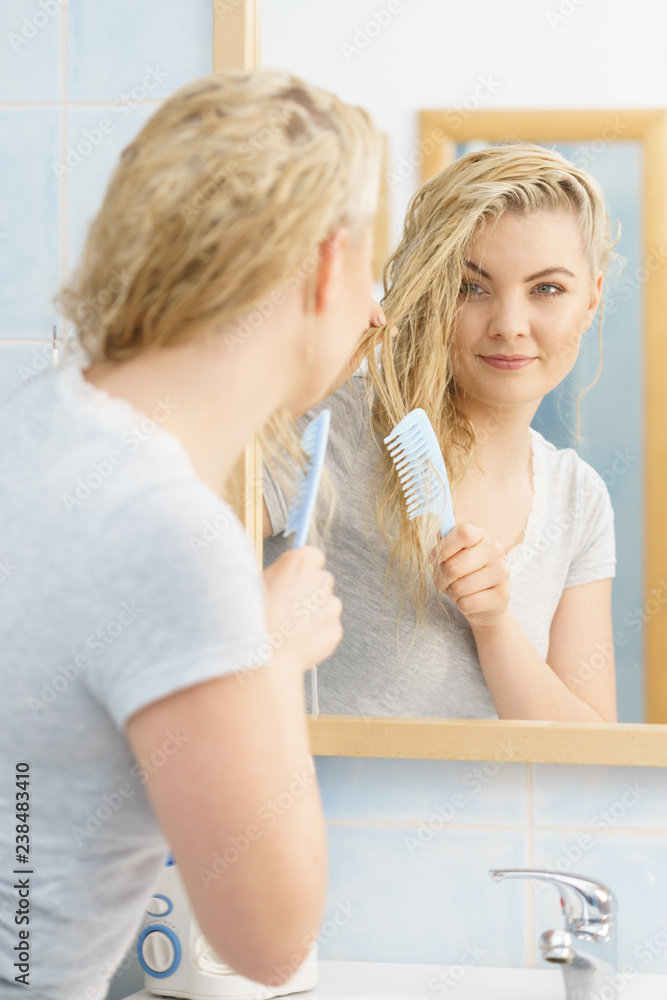 Woman brushing her wet blonde hair Woman brushing her wet blonde hair