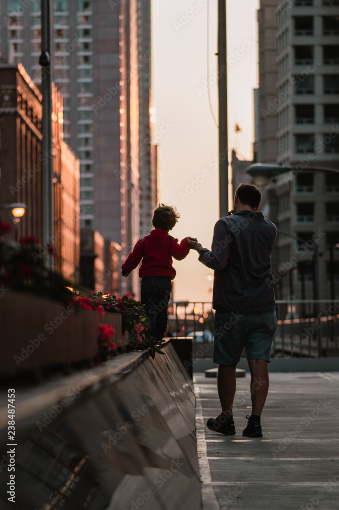 father and son walking in city