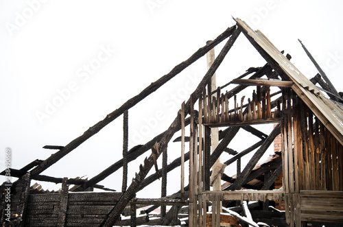 home insurance, burned down house in the winter, snow, rooftop fire damage, insurance of housing photo