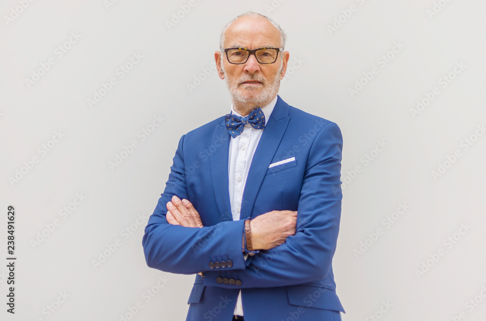 Portrait of confident senior man in suit with arms crossed standing against white background Portrait of confident senior man in suit with arms crossed standing against white background