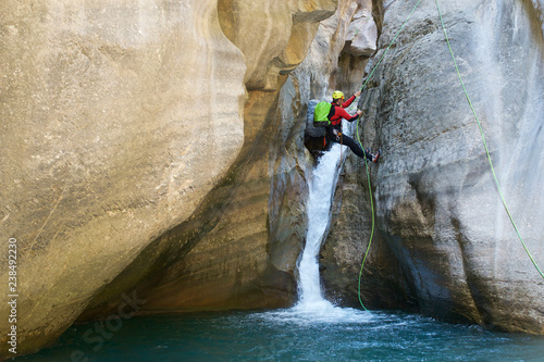 Hiker rappelling on Pyrenees over river photo