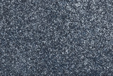 Dark gray sparkling background from small sequins, closeup. Brilliant backdrop.