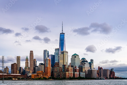 Modern buildings by Hudson River against sky during sunset