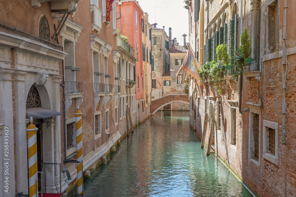 View of an empty romantic canal filled with sunlight. Venice, Italy.