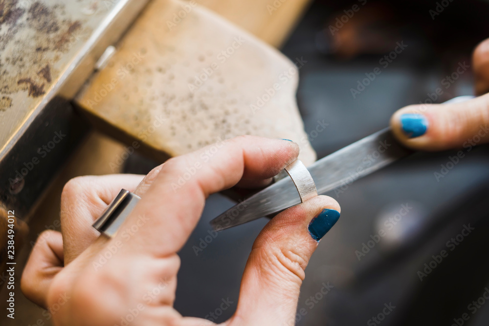 Cropped hands of female jeweller shaping ring with rasp in workshop Cropped hands of female jeweller shaping ring with rasp in workshop