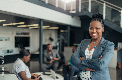 Portrait of a confident black businesswoman with all african american team in the background