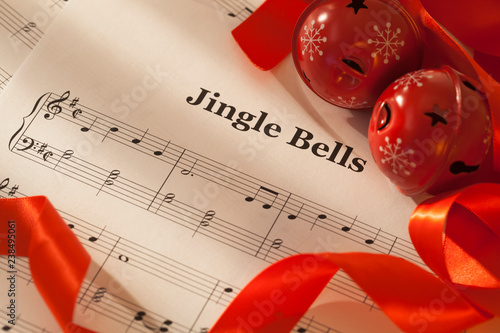 Jingle bells sheet music with red ribbon and jingle bells