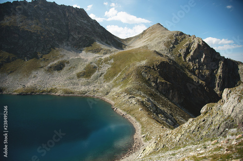 Landscape of highland lake high in the mountains of Dombai. Circus formed by a glacier with a deep lake and blue water