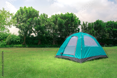 Monodome tent camping on green park and view of trees and sky behind tent