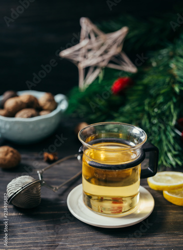 cup of tea on wooden table with blurred christmas tree in background