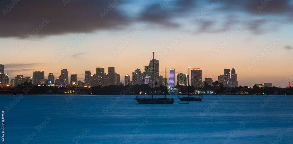 Long time exposure of the Miami skyline, with a boat in the foreground, as seen from Miami Beach.