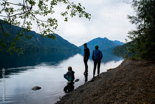 Father with children on lakeshore in Olympic National Park