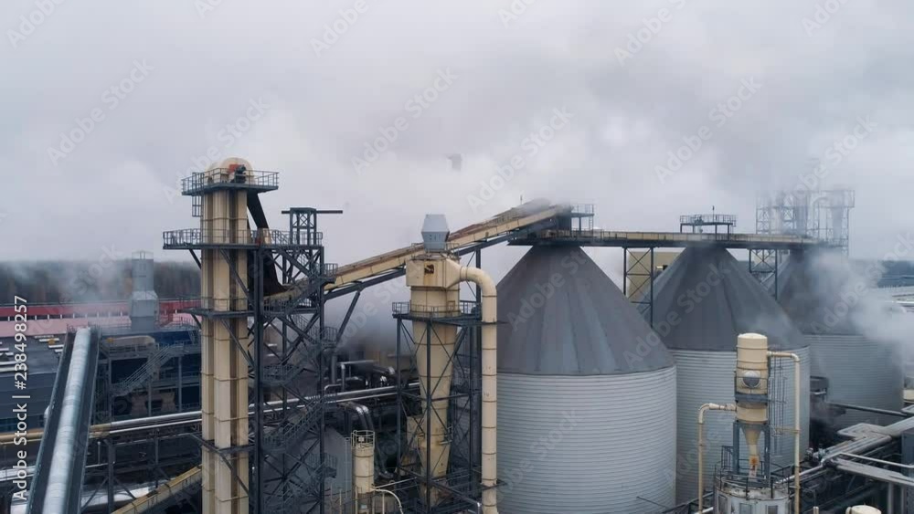 Woodworking factory aerial view of pipes and tanks, industrial landscape, smoke from pipes. Woodworking factory aerial view of pipes and tanks, industrial landscape, smoke from pipes.