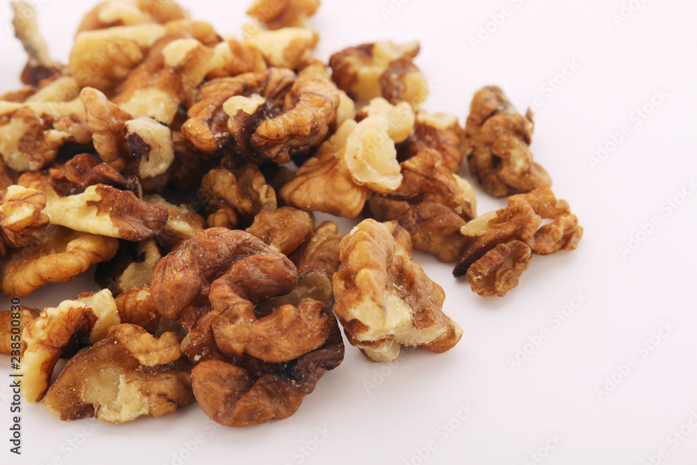 A pile of peeled walnuts at white background A pile of peeled walnuts at white background