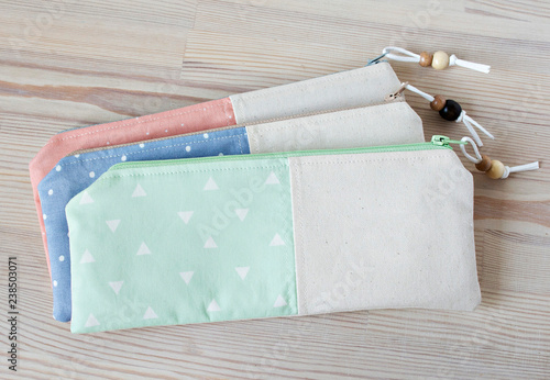 Handmade cotton pencil cases with beads on the wooden table