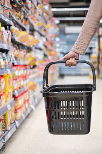 A woman is holding the empty basket in super market photo