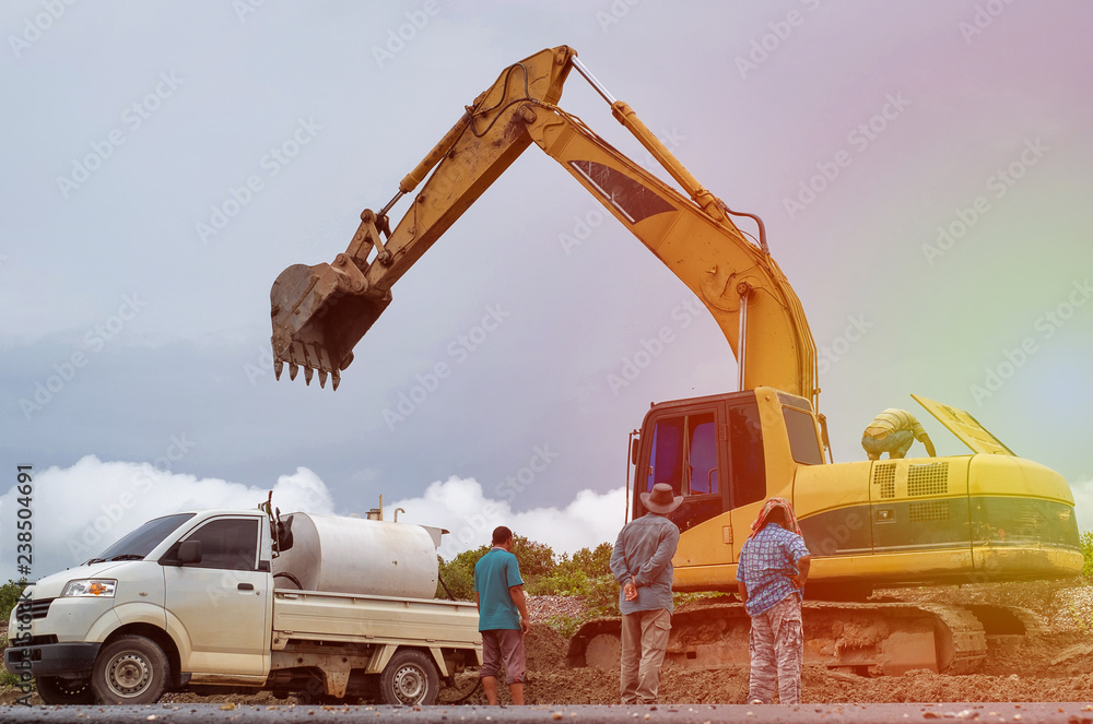 Naklejka premium Group of men and backhoe on construction site. with sun light