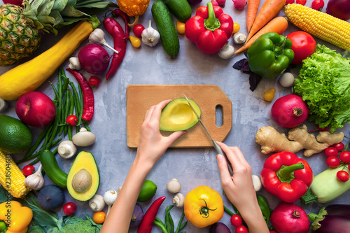 Hands cook healthy colorful spicy flavoured seasoning with fresh summer organic antioxidant fruits and vegetables for vegan or vegetarian recipes isolated on grey background. Healthy lifestyle concept