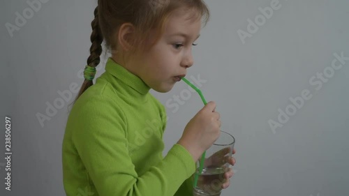 Little girl drinking water from a glass