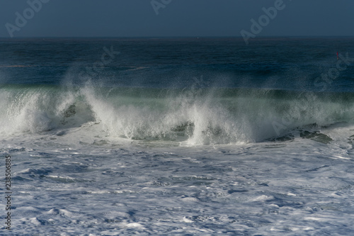 Foamy Atlantic ocean wave on Nazare city beach  Portugal.