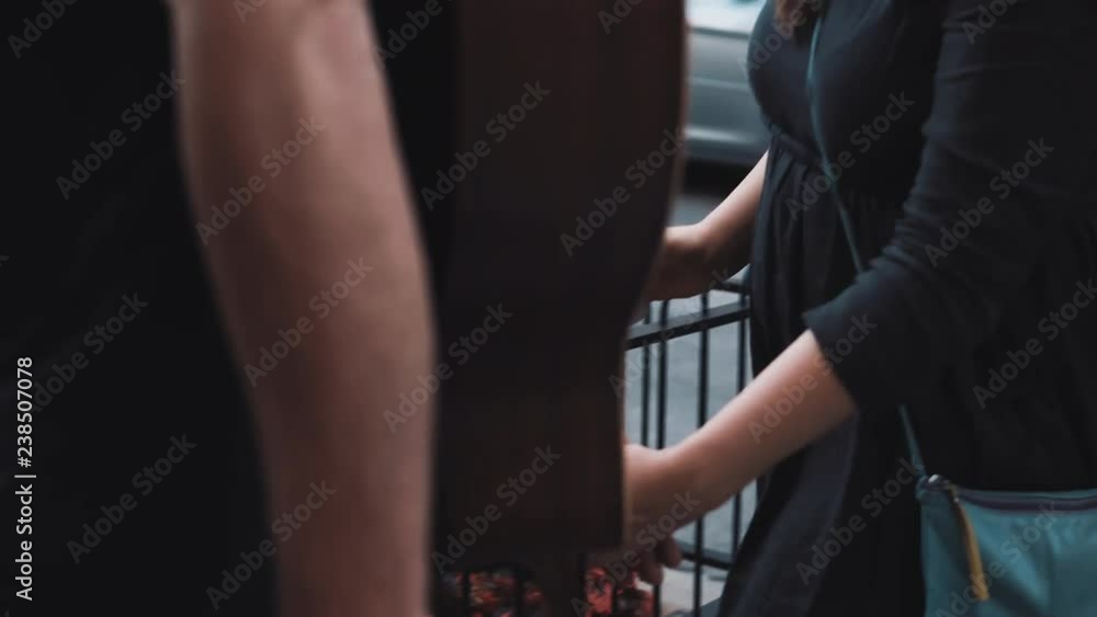 Millennial romantic couple hug in a busy street. European guy with guitar and girl hold hands. Wind blowing in hair 4K. Millennial romantic couple hug in a busy street. European guy with guitar and girl hold hands. Wind blowing in hair 4K.