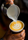 African Coffee Barista pouring a leaf shape with milk foam