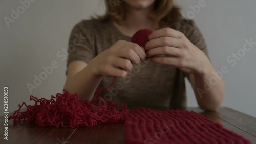 Woman clewing red yarn up