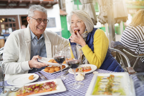 Attractive senior couple eating tapas outdoors