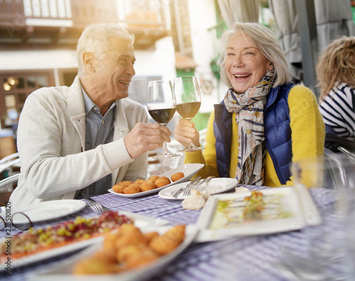 Attractive senior couple eating tapas outdoors