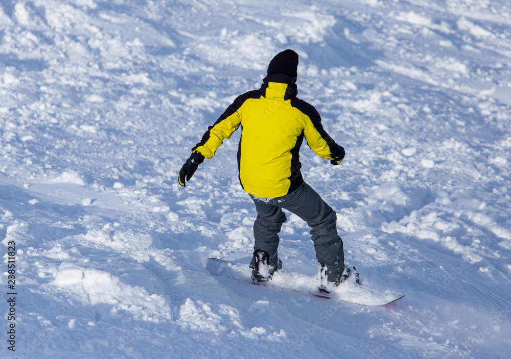 A man snowboarding a mountain in the snow in winter