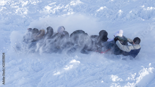 People sledding from the mountain in winter