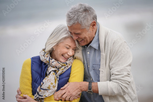  Portrait of happy senior couple embracing on the beach © goodluz